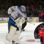 O goleiro do Blues, Jordan Binnington, tenta roubar o disco do 900º gol de Alex Ovechkin.
