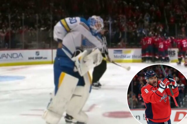 O goleiro do Blues, Jordan Binnington, tenta roubar o disco O goleiro do Blues, Jordan Binnington, tenta roubar o disco do 900º gol de Alex Ovechkin.