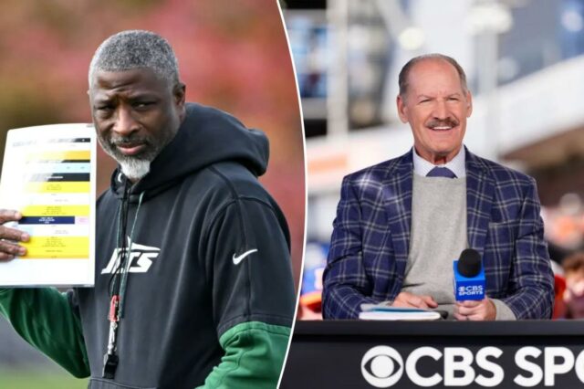 O locutor da CBS Sports, Bill Cowher, sorrindo atrás de uma mesa com um microfone.