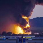 Jon Cherry / AP - FOTO: Fumaça e chamas subindo do local da queda de um avião de carga da UPS fora do Aeroporto Internacional de Louisville, em Louisville, Kentucky, 4 de novembro de 2025.