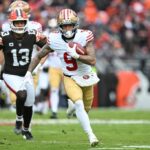O tight end do San Francisco 49ers, George Kittle, no topo, é abordado pelo safety Grant Delpit (9) do Cleveland Browns durante a primeira metade de um jogo de futebol americano da NFL, domingo, 30 de novembro de 2025, em Cleveland. (Foto AP/Sue Ogrocki)