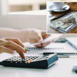 Uma pessoa usa uma calculadora e segura uma nota, cuidando da papelada em uma mesa.