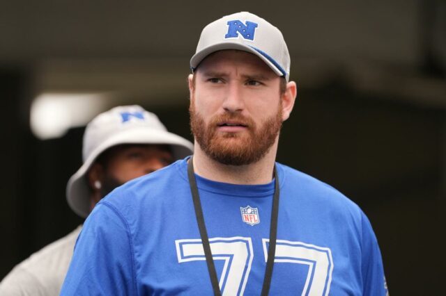 Jared Goff nº 16 do Detroit Lions conversa com Frank Ragnow nº 77 antes de um jogo de futebol americano da NFL contra o Minnesota Vikings.