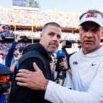 College football head coach Billy Napier of the Florida Gators (L) right shakes hands with Head coach Lane Kiffin of the Ole Miss Rebels
