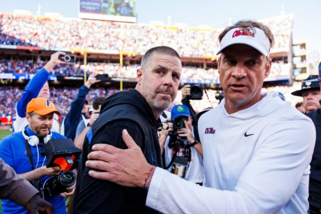 College football head coach Billy Napier of the Florida Gators (L) right shakes hands with Head coach Lane Kiffin of the Ole Miss Rebels