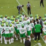 The Oregon Ducks huddle on the field during a Pac-12 NCAA college football game against the Stanford Cardinal