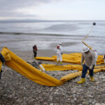 ARQUIVO - Equipes de limpeza removem areia carregada de óleo na praia de Refugio State Beach, local de um derramamento de óleo, ao norte de Goleta, Califórnia, 20 de maio de 2015. (AP Photo / Michael A. Mariant, Arquivo)