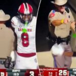 O soldado do Texas se posicionando entre dois jogadores da Carolina do Sul após marcar um touchdown.