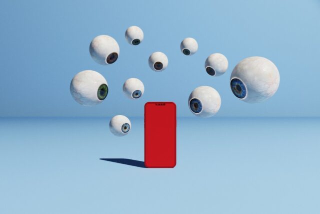 Conceptual image with a bunch of floating eyeballs in different sizes surrounding a red phone, could symbolize ideas around cyber security, surveillance, and spyware.