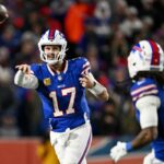 Patrick Mahomes, Travis Kelce e outros jogadores do Kansas City Chiefs andando em um corredor.