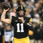 O quarterback do Oregon, Dante Moore, com uniforme se aquecendo.