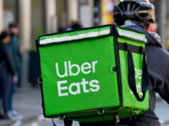 Problemas financeiros empurram cada vez mais australianos para atividades paralelas Cardiff, País de Gales - março de 2022: Motoboy do serviço de entrega de comida Uber Eats percorrendo o centro da cidade