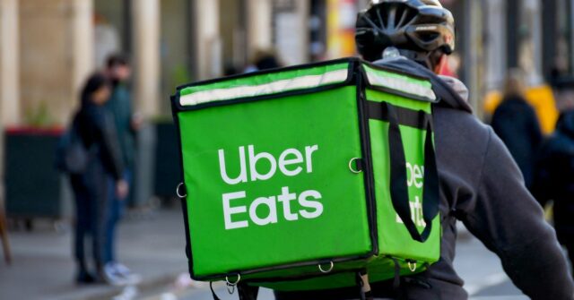Cardiff, País de Gales - março de 2022: Motoboy do serviço de entrega de comida Uber Eats percorrendo o centro da cidade