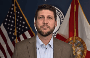 Procurador-geral da Flórida quer aumento de penalidades para jogos ilegais O procurador-geral da Flórida quer o aumento das penalidades para jogos de azar ilegais. O procurador-geral James Uthmeier, de blazer marrom e camisa clara, fica em frente às bandeiras dos EUA e da Flórida