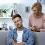 Bebê bebendo de uma mamadeira segurada por uma mulher.