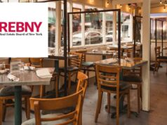 Questões de restaurantes em pauta na confabulação REBNY: ‘Hospitality Meets Real Estate’ Área de jantar externa de um restaurante de Nova York instalada em uma calçada com mesas vazias e divisórias transparentes.