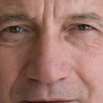 Um infográfico listando sete exemplos da realidade da saúde dos homens, ilustrados com um jovem negro em estado de angústia. -Rula