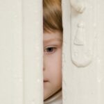 Roblox exige que crianças de até nove anos enviem um vídeo selfie para verificação de idade | Foto de uma criança espiando por uma porta parcialmente aberta