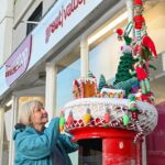 Yarnbomber Suzy Jackson ajustando a cobertura final da caixa de correio fora do Titchfield Post Office