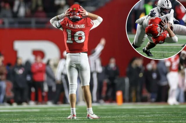 Rutgers cai para a Penn State pela 18ª vez consecutiva O quarterback do Rutgers, Athan Kaliakman, está reagindo a uma jogada com as mãos no capacete.
