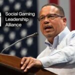 SGLA critica a repressão da Minnesota AG aos cassinos de sorteios como uma ação equivocada. O procurador-geral de Minnesota, Keith Ellison, em um pódio com a bandeira dos EUA ao fundo, com o logotipo da Social Gaming Leadership Alliance ao lado.