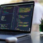 Sites de assistência de codificação expuseram credenciais de bancos, agências governamentais e muito mais | Código do site mostrado na tela do MacBook