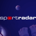 Logotipo da Sportradar exibido em um fundo azul escuro com elementos esportivos estilizados, incluindo bola de tênis, bola de golfe, basquete, bola de futebol e luvas de goleiro. Sportradar adquire IMG ARENA para impulsionar esforços globais de expansão de dados esportivos