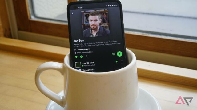 Spotify está finalmente trazendo videoclipes para os EUA Logotipo do Spotify usando fones de ouvido pretos, cercado por ícones flutuantes de notas musicais verdes em um fundo gradiente.