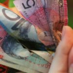 Alguém segurando um punhado de dinheiro australiano.