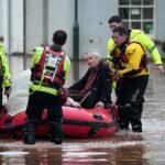 Os serviços de emergência ajudam pessoas numa rua inundada em Monmouth, País de Gales.