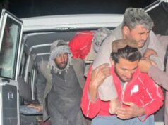 Terremoto mortal de magnitude 6,3 atinge norte do Afeganistão Uma mulher idosa está sentada em uma maca em um hospital. Uma bandagem cobre a cabeça e os olhos. Uma mulher segurando uma criança observa.