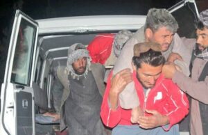 Terremoto mortal de magnitude 6,3 atinge norte do Afeganistão Uma mulher idosa está sentada em uma maca em um hospital. Uma bandagem cobre a cabeça e os olhos. Uma mulher segurando uma criança observa.