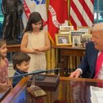 O presidente Donald Trump cumprimenta os netos da jornalista Salena Zito no Salão Oval.