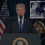 O presidente Trump fazendo comentários em um pódio com o selo presidencial, ladeado pelas bandeiras dos EUA e presidenciais.