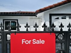 Trump está considerando hipotecas portáteis – veja como elas funcionam Modelo de casas em uma pilha de moedas e notas.