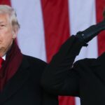 O presidente Donald Trump e o vice-presidente JD Vance saudam durante uma cerimônia no Memorial Amphitheatre no Cemitério Nacional de Arlington para marcar o Dia dos Veteranos em 11 de novembro de 2025, em Arlington, Virgínia.