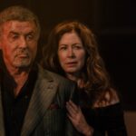 A man and a woman stand bathed in orange light