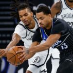 Ziaire Williams (à esquerda) enfrenta o guarda do Orlando, Jeff Howard, na batalha por uma bola perdida durante a derrota do Nets por 105-98 para o Magic em 14 de novembro de 2025.