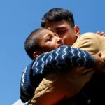 pessoas seguram fotografias em um protesto em uma rua