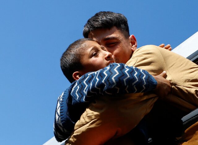 pessoas seguram fotografias em um protesto em uma rua