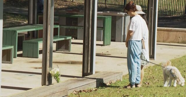 ‘Eu esfaqueei outro menino’: adolescente acusado de esfaqueamento fatal para Duas pessoas deixando flores em um parque onde um adolescente teria sido esfaqueado mortalmente.