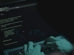 ‘Listas de otários’: por que você nunca deve pagar um golpista de ransomware hacker encapuzado sem rosto mostrando gesto de silêncio. Ataque de hackers. Perigoso hacker encapuzado invade servidores de dados do governo. Cibersegurança, hacker de computador com capuz. Conceito de hacking e malware.