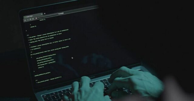 ‘Listas de otários’: por que você nunca deve pagar um hacker encapuzado sem rosto mostrando gesto de silêncio. Ataque de hackers. Perigoso hacker encapuzado invade servidores de dados do governo. Cibersegurança, hacker de computador com capuz. Conceito de hacking e malware.