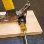 Furadeira e chave Allen sendo usadas para extrair o gancho