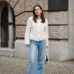 HAMBURGO, ALEMANHA - 16 DE OUTUBRO: Laura Noltemeyer é vista vestindo um suéter enorme de lã de alpaca bege com detalhes de amarração nas costas de Aylin K√∂nig; uma saia longa tricotada de lã de alpaca com corte reto de Aylin K√∂nig; um lenço de malha de alpaca enrolado e amarrado no pescoço por Aylin K√∂nig; uma bolsa de couro intrecciato branco chamada ‚ÄûArco Bag‚Äú da Bottega Veneta; óculos de sol pretos finos tipo gatinho da Yves Saint Laurent; brincos extravagantes em ouro com detalhe de pedra verde da Mango; seu cabelo castanho e liso está preso em um rabo de cavalo baixo em 16 de outubro de 2025 em Hamburgo, Alemanha. (Foto de Moritz Scholz/Getty Images)