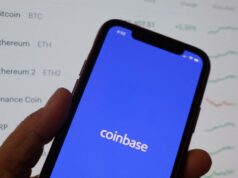 A Coinbase começa a integrar usuários novamente na Índia, planeja uma expansão fiduciária no próximo ano Coinbase's logo on a phone in front of crypto prices