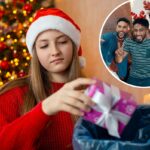 Uma jovem infeliz com chapéu de Papai Noel joga um presente de Natal em uma lixeira.