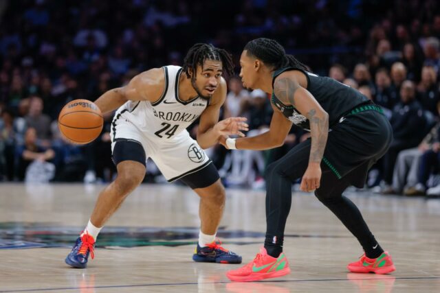 O guarda do Brooklyn Nets, Cam Thomas (24), segura a bola enquanto o guarda do Minnesota Timberwolves, Rob Dillingham, defende.