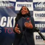 Jasmine Crockett fala aos apoiadores com uma placa que diz