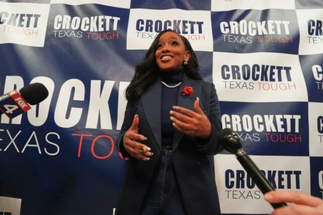 A candidatura de Jasmine Crockett ao Senado do Texas foi Jasmine Crockett fala aos apoiadores com uma placa que diz